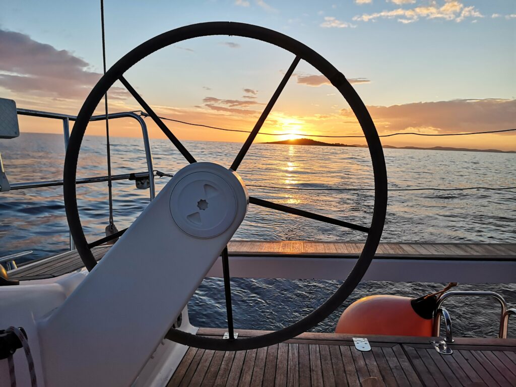 Sailing during sunset - White Wake Sailing
